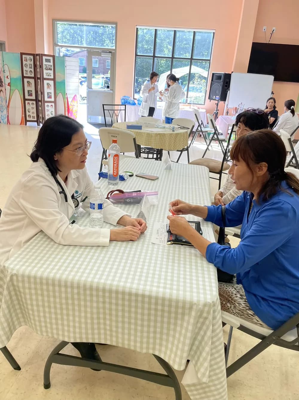 A CCHPA healthcare professional speaking with a community member at a health fair